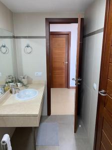 Casa Marla mit 3 Schlafzimmern und 2 Badezimmern في بويرتو كاليرو: حمام مع حوض وباب خشبي