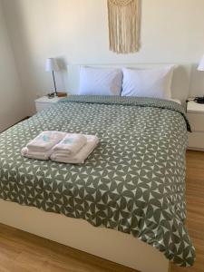 a bedroom with a bed with two towels on it at J&B Maisonette House in Marmari