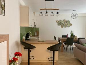 ハイドゥソボスローにあるÁrmin Apartmanのテーブルと椅子のあるキッチンとリビングルーム