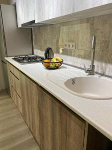 a kitchen counter with a sink and a stove at Duplex apartment near the forest in Bakuriani