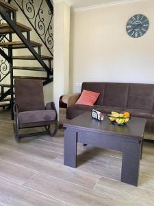 a living room with a couch and a table and a chair at Duplex apartment near the forest in Bakuriani