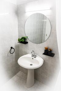 uma casa de banho com um lavatório branco e um espelho. em Stacy's Studios em Kremasti