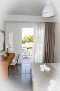 a bedroom with a bed and a desk and a window at Stacy's Studios in Kremasti