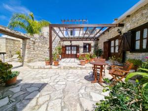 a patio with a table and chairs and a building at Poseidon's Pool Paradise in Skarinou