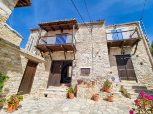 an old stone building with potted plants in front of it at Poseidon's Pool Paradise in Skarinou
