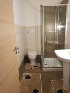 La salle de bains est pourvue de toilettes, d'une douche et d'un lavabo. dans l'établissement appartamento nel residence felicita, à Balestrate