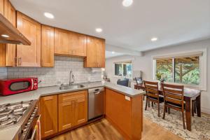 a kitchen with wooden cabinets and a table and chairs at Central Crocker Highlands Garden Oasis in Oakland