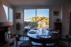 a dining room with a table and a large window at Les Balcons du Roucas Blanc in Marseille