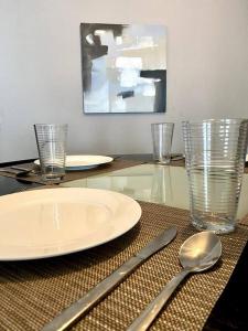 a table with a plate and two glasses and a spoon at Apartamento con excelente ubicación! Hasta 4 Personas in Panama City