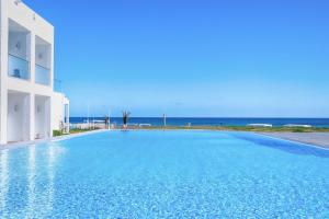 a swimming pool with the ocean in the background at Amber El Fell in Hammamet Nord