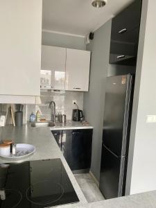 a kitchen with a black refrigerator and a sink at Apartament Poznańska 24 in Bydgoszcz