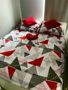 a quilt on a bed with red pillows on it at Apartament Poznańska 24 in Bydgoszcz