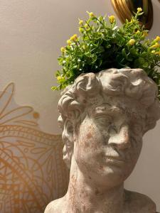 a statue with a plant on top of its head at B&B LE CUSPIDI in Ginosa