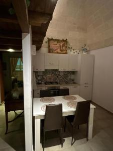 a kitchen with a white table and chairs in it at B&B LE CUSPIDI in Ginosa