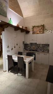 a kitchen with a white table and chairs at B&B LE CUSPIDI in Ginosa