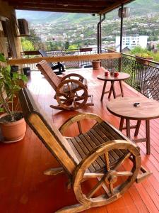un banco de madera sentado en una terraza con mesas en Guest House Anahit Ijevan en Ijevan