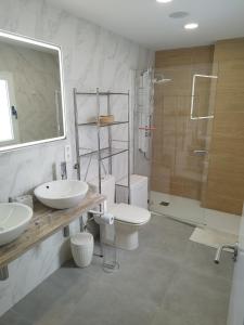 a bathroom with two sinks and a toilet and a shower at HJS Guest House - The Comfy Retreat in Las Palmas de Gran Canaria