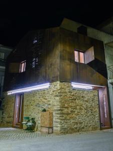 a building with a stone wall at night at Casa do Ferreiro in Macedo de Cavaleiros