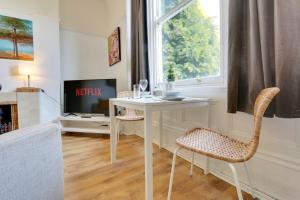 a living room with a table and chairs and a tv at Convenient 1-Bed Apartment - Ideal for Working Away, Free Parking, Pet Friendly, Netflix in Sheffield