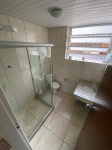 a bathroom with a glass shower and a toilet at Hotel Montanus in Nova Friburgo