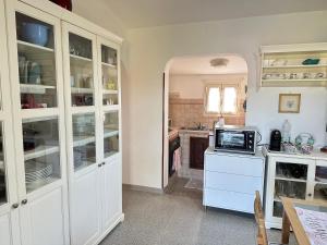 eine Küche mit weißen Schränken und einer Mikrowelle in der Unterkunft CASA IL PINO in Orbetello