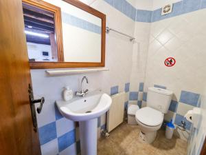 a bathroom with a sink and a toilet and a mirror at Poseidon's Pool Paradise in Skarinou