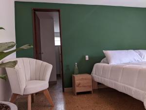 a bedroom with a bed and a chair and a mirror at Habitación privada en el Poblado. Lo mejor de Medellín muy cerca in Medellín