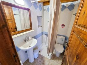 a bathroom with a sink and a toilet at Poseidon's Pool Paradise in Skarinou