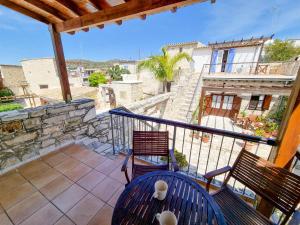 a balcony with two chairs and a view of a building at Poseidon's Pool Paradise in Skarinou