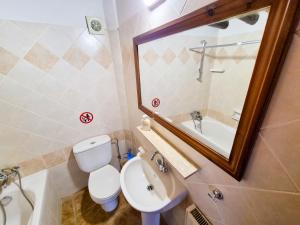 a bathroom with a toilet and a sink and a mirror at Poseidon's Pool Paradise in Skarinou