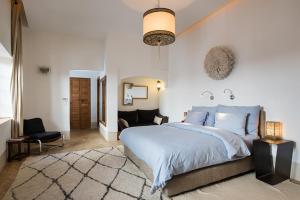 - une chambre avec un grand lit et une chaise dans l'établissement Riad Rossi, à Marrakech