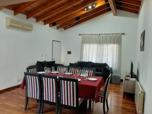 a dining room with a table with wine glasses on it at Casa DELUXE MALBEC , Barrio Privado, con cochera doble, jardín y churrasquera in Mendoza