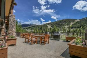 a patio with a table and chairs and a grill at Hidden River Lodge 5977 in Keystone