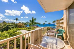 uma varanda com uma mesa e cadeiras e o oceano em Nani Kai Hale 501, 1 Bedroom, Ocean Front, WiFi, Pool Access, Sleeps 4 em Kihei