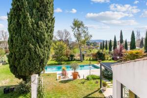 uma vista para um pátio com uma piscina e árvores em Villa Massilia - Welkeys em Aubagne