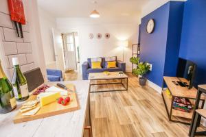 ein Wohnzimmer mit blauen Wänden und einem blauen Sofa in der Unterkunft Lake View Apartments, Oulton Broad in Lowestoft