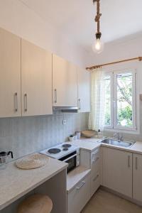 a kitchen with white cabinets and a sink at Matina's studio in Póros Kefalonias
