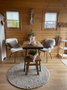 a living room with a table and chairs in a room at Cabin De Duinweg: direct aan duin en bos in Noordwijk