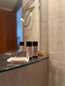 a bathroom counter with two bottles on a shelf at Limeni Studios in Limeni