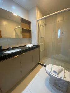 een badkamer met een douche, een wastafel en een toilet bij Mana Beach Flat Prime in Ipojuca