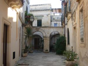 an alley between two buildings with potted plants at Secret Garden In The Old Town in Lecce
