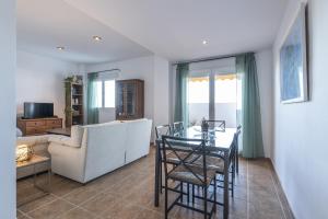 ein Wohnzimmer mit einem Sofa und einem Tisch in der Unterkunft ÁTICO ATALAYA Parking privado gratis in Ayamonte