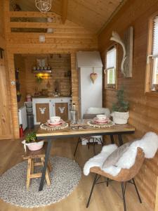 諾德韋克的住宿－Cabin De Duinweg: direct aan duin en bos，小屋内带桌椅的用餐室