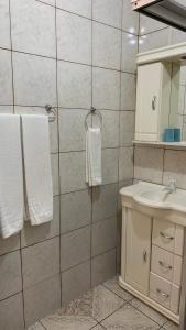 uma casa de banho com lavatório, espelho e toalhas em Pousada Simone em Cambará
