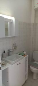 bagno bianco con lavandino e servizi igienici di Beatrice's apartment ad Acharavi