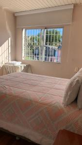 um quarto com uma cama grande e uma janela grande em Pousada Simone em Cambará