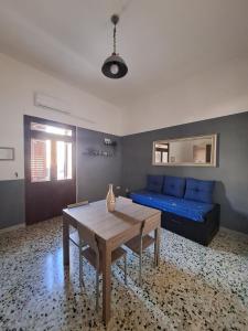 uma sala de estar com um sofá azul e uma mesa em La Casa del Borgo em Lecce