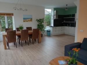 uma cozinha e sala de estar com mesa e cadeiras em Het Dijkstuk em Noordwijkerhout