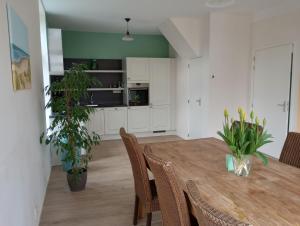 een keuken en eetkamer met een houten tafel en stoelen bij Het Dijkstuk in Noordwijkerhout