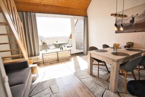 a dining room with a table and a large window at Traumblick in Sankt Andreasberg